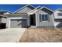 New construction home with gray siding, attached garage, and a concrete driveway at 9112 Telluride Ct, Commerce City, CO 80022