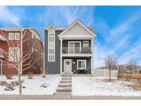 Charming two-story home with grey siding, white trim, and a cozy front balcony perfect for enjoying the neighborhood views at 18552 E 54Th Ave, Denver, CO 80249
