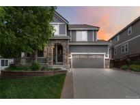 Charming two-story home featuring a brick facade, covered porch and manicured lawn, showcasing curb appeal at 2828 Shadow Dance Dr, Castle Rock, CO 80109