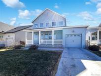 Charming, light blue home with a covered front porch and attached one-car garage at 4742 Quandary Peak St, Brighton, CO 80601