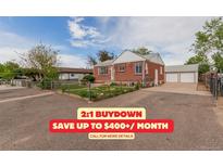 Charming brick home featuring a well-maintained front yard and a detached two-car garage at 8110 Ivy St, Commerce City, CO 80022