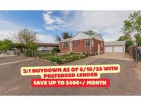 Charming brick home featuring a manicured lawn and a detached two-car garage at 8110 Ivy St, Commerce City, CO 80022