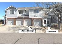 Charming townhome featuring a front door, attached garage, and manicured landscaping at 10259 W 55Th Dr # 103, Arvada, CO 80002