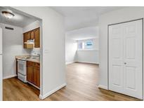 An open floor plan showcases the kitchen with white appliances and wood floors throughout at 3613 S Sheridan Blvd # 7, Denver, CO 80235