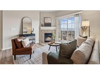 Inviting living room featuring a fireplace, balcony access with scenic views, and comfortable seating at 1062 Rockhurst Dr # 401, Highlands Ranch, CO 80129