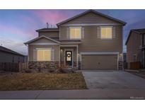 Charming two-story home with stone accents, a two-car garage, and a welcoming front door with a wreath at 14799 Longhorn Dr, Mead, CO 80542