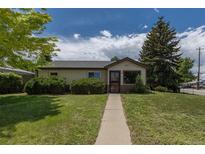 Charming single-story home featuring a well-manicured lawn, pathway, and curb appeal at 1099 Wheeling St, Aurora, CO 80011