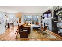 Bright living room boasts hardwood floors, fireplace, built-ins, and access to a private balcony at 111 S Monroe St # B203, Denver, CO 80209