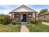 Charming single story home featuring a cozy front porch and meticulously landscaped front yard at 3464 S Downing St, Englewood, CO 80113