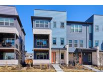 Modern townhome featuring a two-story facade, balcony, and a bright orange front door at 6240 N Dayton Ct, Denver, CO 80238