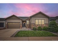 Inviting home with a landscaped lawn, stone accents, and a two-car garage, perfect for suburban living at 7442 Greenwater Cir, Castle Rock, CO 80108