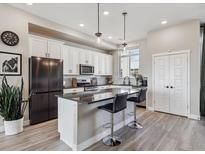 Charming kitchen with stainless steel appliances, island seating, and modern lighting at 2225 S Poppy St, Lakewood, CO 80228