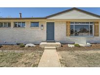 Charming single-story home with a blue front door and white brick exterior at 6923 S Albion St, Centennial, CO 80122