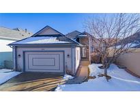 Ranch style home with attached garage, snowy front yard, and walkway at 1950 Five Iron Dr, Castle Rock, CO 80104