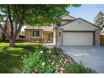 Charming two-story home with a well-manicured lawn and a lovely flower garden in front at 17657 E Prentice Cir, Aurora, CO 80015