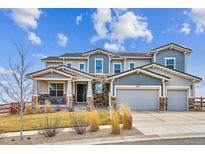 Two-story home with a stone and siding exterior, three-car garage, covered porch, and well-manicured front lawn at 16272 W 95Th Ln, Arvada, CO 80007