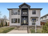 Striking modern home featuring a two-story entryway, second story balcony, and board and batten siding at 2635 S Monroe St, Denver, CO 80210