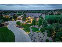 Stunning exterior view of the estate home with lush landscaping, a circular driveway, and a beautiful horizon view at 4822 Bandera Pl, Parker, CO 80134