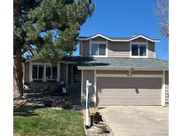 Charming two-story home featuring a well-maintained lawn, gray siding, and an attached two-car garage at 8975 S Coyote St, Highlands Ranch, CO 80126