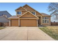 Inviting two-story home with a three car garage and charming exterior details under a bright blue sky at 1045 English Sparrow Trl, Highlands Ranch, CO 80129
