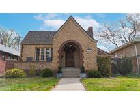 Charming brick home with arched entry, lovely landscaping, and a classic, inviting facade at 1582 Fairfax St, Denver, CO 80220
