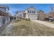 Charming two-story home with a well-maintained lawn and attached two-car garage at 16149 Peregrine Dr, Parker, CO 80134