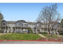 Attractive townhomes with blue and gray siding, manicured lawns, and steps leading to front doors at 19213 E Idaho Dr # 105, Aurora, CO 80017