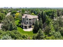 Stunning home featuring mature trees, a large yard, and a spacious deck perfect for outdoor entertaining at 5301 S Birch Ct, Greenwood Village, CO 80121