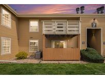 A charming condo exterior with a private patio area and balcony under a beautiful sunset sky at 10251 W 44Th Ave # 7-106, Wheat Ridge, CO 80033
