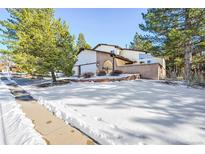 Beautiful home with snow-covered front yard and mature trees at 118 S Eldridge Way, Golden, CO 80401