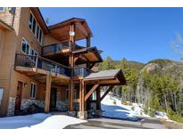 A three story home has a wooden exterior with a stone foundation and multiple covered decks at 10508 Christopher Dr, Conifer, CO 80433