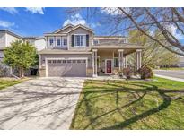 Beautiful two-story home with a well-maintained lawn and covered front porch at 19447 E Bellisario Creek Dr, Parker, CO 80134