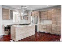 Modern kitchen features light wood cabinets, stainless steel appliances, and island cooktop at 3619 Navajo St, Denver, CO 80211