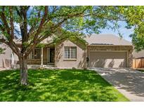 Charming single-Gathering home with brick exterior, lush lawn, and mature tree providing shade at 3563 Watada Dr, Brighton, CO 80601