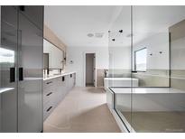 Bright, spacious bathroom featuring a large glass shower, soaking tub, and modern vanity with dual sinks at 5031 Moss Pl, Golden, CO 80403