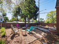 Charming backyard with a cozy fire pit and colorful Adirondack chairs, perfect for outdoor relaxation at 3401 N Steele St, Denver, CO 80205