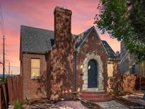 Brick home with a charming entry and chimney silhouetted against a vibrant sunset sky at 3401 N Steele St, Denver, CO 80205