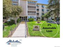 Inviting condo building exterior with manicured lawn and accessible ramp entrance at 3164 S Wheeling Way # 302, Aurora, CO 80014