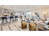 Bright open-concept living room featuring bar seating, hardwood floors, and modern decor at 3440 Chase St, Wheat Ridge, CO 80212
