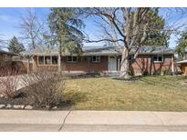 Charming brick home featuring a well-manicured front yard with mature trees and established landscaping at 7209 S Sherman St, Centennial, CO 80122