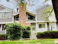 Charming townhome featuring a brick chimney, tidy landscaping, and neutral siding at 6895 W 84Th Way # 4, Arvada, CO 80003