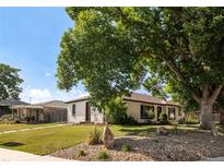 Charming one-story home with a well-manicured lawn and a mix of rock and grass landscaping at 5090 W 36Th Ave, Denver, CO 80212