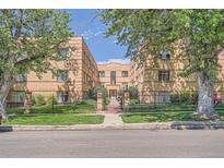 Inviting brick apartment building exterior with manicured lawn, mature trees, and gated entry at 1523 Ivy St # 6, Denver, CO 80220