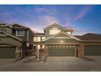 Charming townhome featuring a spacious two-car garage and attractive stone accents at 15063 E Crestridge Dr, Centennial, CO 80015