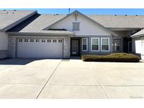 Charming single-story home with a two-car garage, stone accents, a well-maintained lawn and a paved driveway at 7777 S Biloxi Way, Aurora, CO 80016