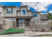 Charming townhome exterior featuring stone accents, covered entry, and well-manicured landscaping at 8943 Tappy Toorie Cir, Highlands Ranch, CO 80129
