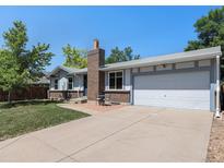 Charming single-Gathering home featuring an attached two-car garage and brick accents against blue sky at 6436 S Kline St, Littleton, CO 80127