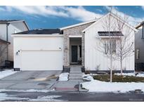 Craftsman style home with white siding, stone accents, and a two-car garage at 6437 Saddlesmith St, Castle Pines, CO 80108