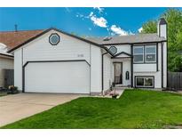 Charming two-story home featuring a white exterior, well-manicured lawn, and attached two-car garage at 9150 W 94Th Ave, Westminster, CO 80021