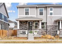 Charming two-story home with a stone facade and inviting front porch entrance at 21823 E 8Th Ave, Aurora, CO 80018